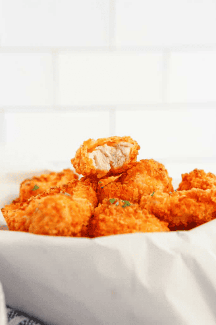 Golden, crispy air fryer popcorn chicken bites served on a plate, ready to eat.