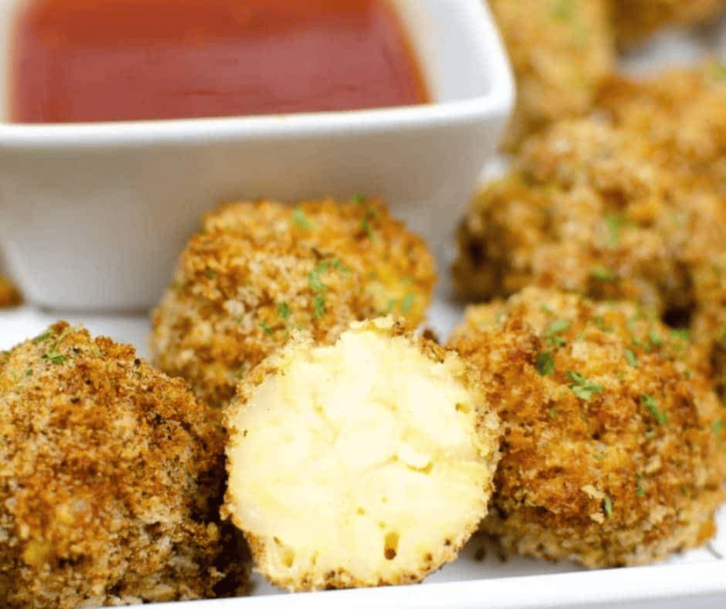 closeup: air fried mac and cheese bites with one sliced down the middle so that the center is visible