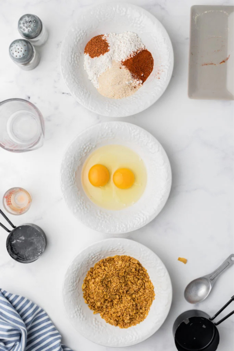 Chicken tenders dipped in egg wash for coating.