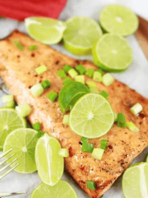 Air fryer firecracker salmon glazed with sweet chili sauce, topped with lime slices and diced scallions