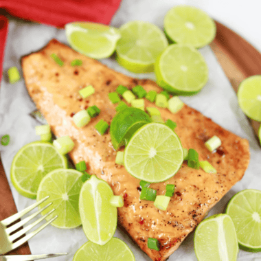 Air fryer firecracker salmon glazed with sweet chili sauce, topped with lime slices and diced scallions