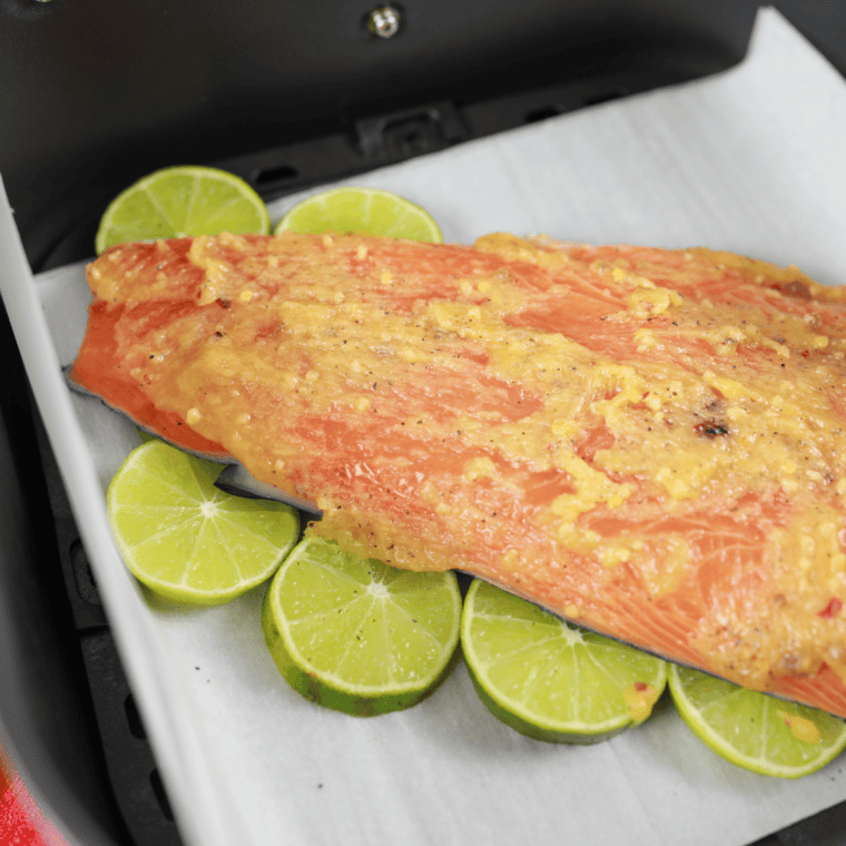 Brushing firecracker glaze over salmon partway through air frying at 400°F