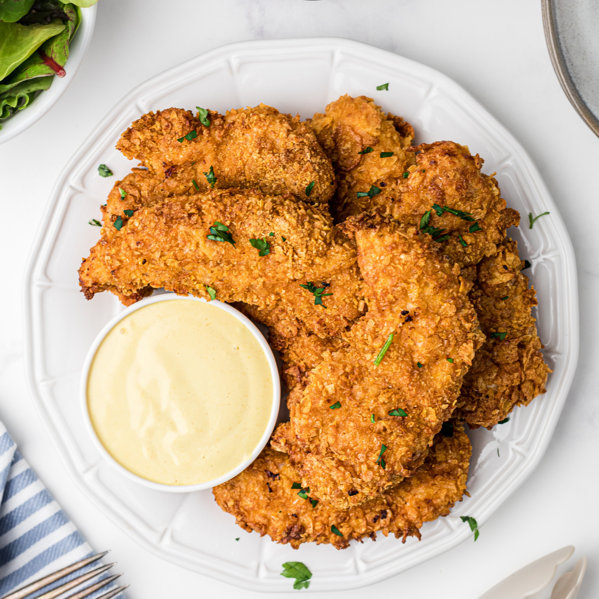
Here are some pro tips for making perfect Copycat Zaxby's Chicken Fingers in an air fryer:

Use Panko Breadcrumbs: Panko breadcrumbs are Japanese breadcrumbs that are larger and airier than traditional breadcrumbs. They result in a crispier, crunchier coating.

Don't Overcrowd the Basket: For the crispiest chicken fingers, make sure they're not touching or overlapping in the air fryer basket. If necessary, cook them in batches.

Shake the Basket: Halfway through the cooking time, you can shake the basket to ensure the chicken fingers are cooking evenly.

Use an Instant-Read Thermometer: The safest way to check if your chicken is done is by using an instant-read thermometer. It should read 165°F (74°C) in the thickest part of the chicken.

Make Your Own Zax Sauce: Zaxby's is famous for their Zax Sauce. Try making your own at home with mayonnaise, ketchup, garlic powder, Worcestershire sauce, and a bit of black pepper.

Pat Dry the Chicken: Make sure to pat dry the chicken tenders before breading them. This helps the coating stick better to the chicken.

Keep the Breading Light: Do not press too hard when applying the breadcrumbs; you want a light, airy coating that gets really crispy.

Spray with Cooking Spray: Just before air frying, spray the chicken fingers with cooking spray. This helps them get golden and crispy.

Remember, the key to perfect chicken fingers is patience and attention to detail. Follow these tips, and you're sure to end up with delicious, crispy, and flavorful chicken fingers!