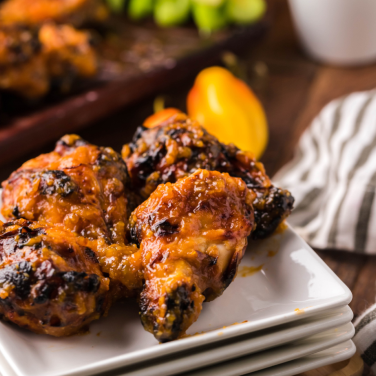 Air Fryer Spicy Apricot Glazed Chicken Wings plated and garnished with green onions.