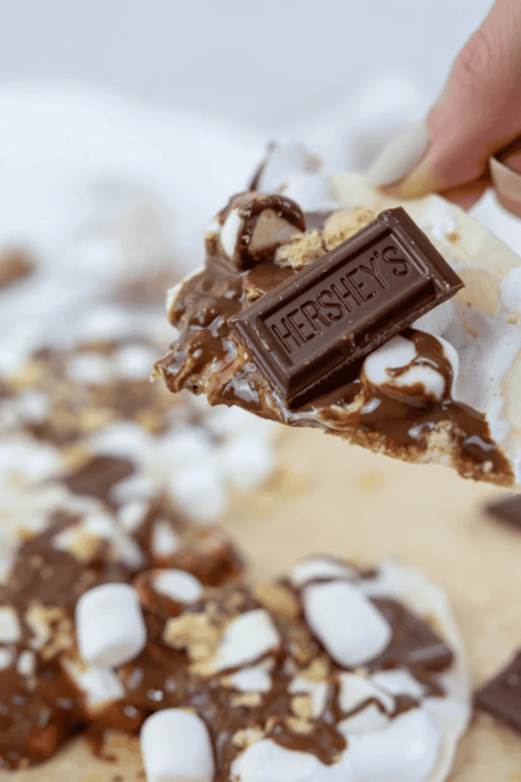 Blackstone Grill S&rsquo;mores Pizza with melted chocolate and toasted marshmallows on a golden crust, served on a griddle.