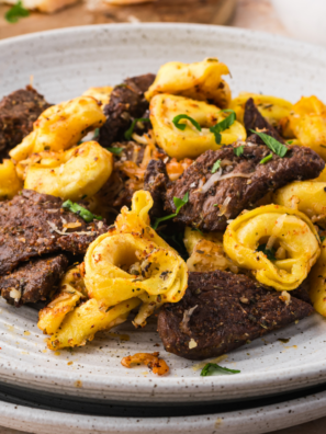Blackstone tortellini cooked on griddle with sausage, cheese pasta, and vegetables
