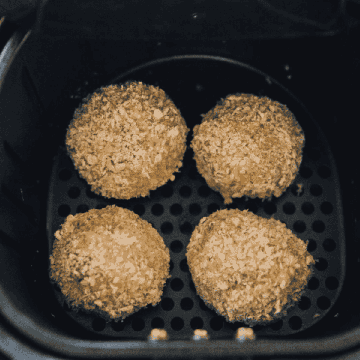 Golden air fryer arancini rice balls on a plate, crispy outside with melty cheese centers, ready to serve.