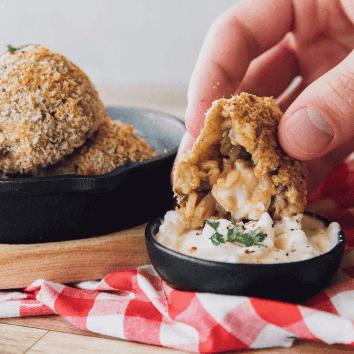 Crispy air fryer arancini served on a plate, with one broken open showing a melted cheese center.