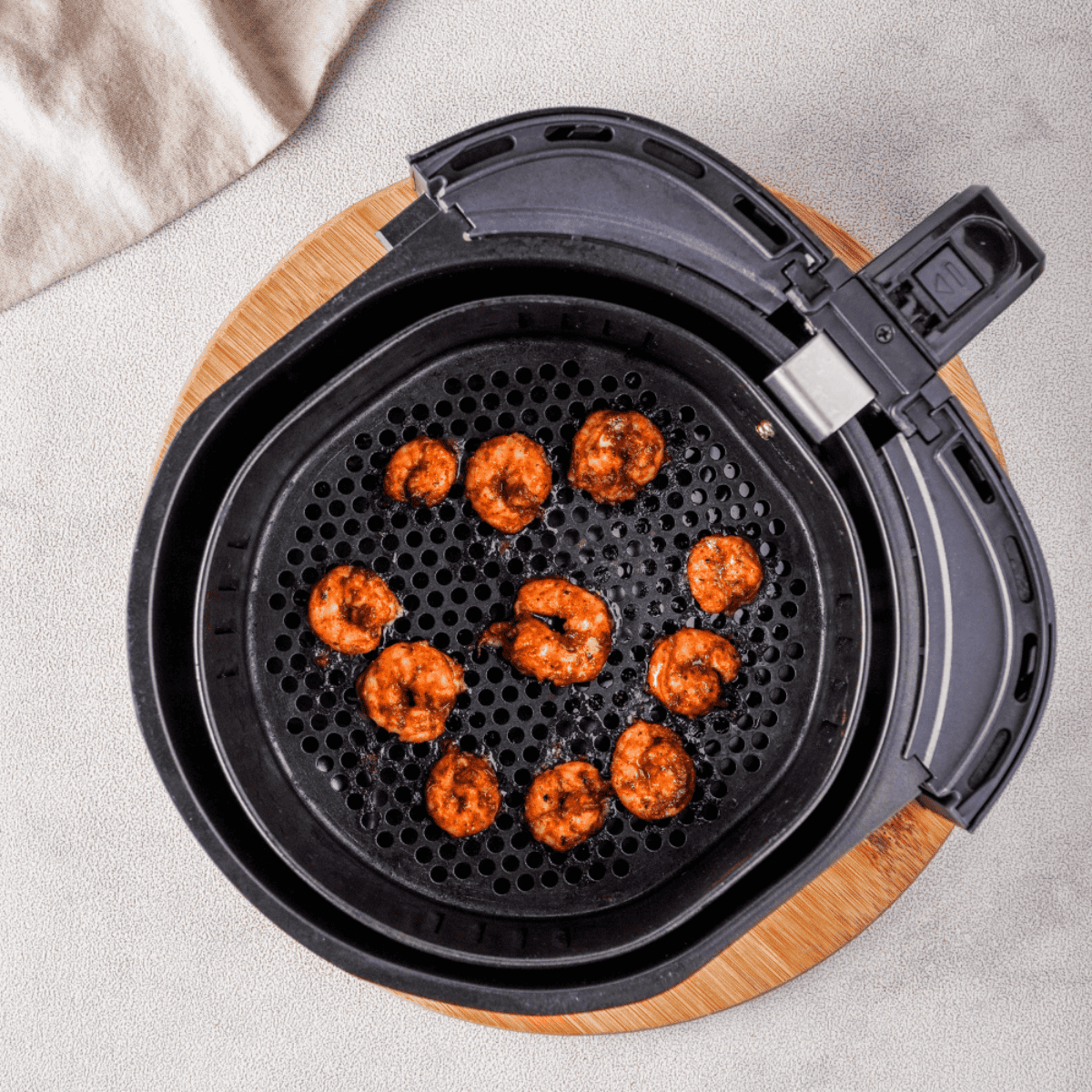 Cooked shrimp in the air fryer basket.