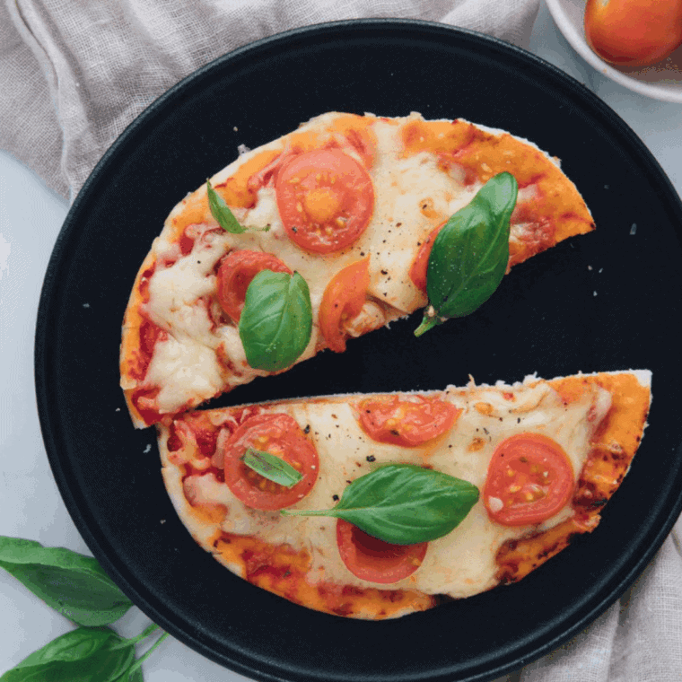 Homemade Cheesecake Factory Margherita Flatbread Pizza topped with melted mozzarella, fresh basil, and juicy tomatoes on a golden crispy crust.