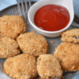 Golden crispy air fryer fried zucchini slices, served with dipping sauce, inspired by Cheesecake Factory.