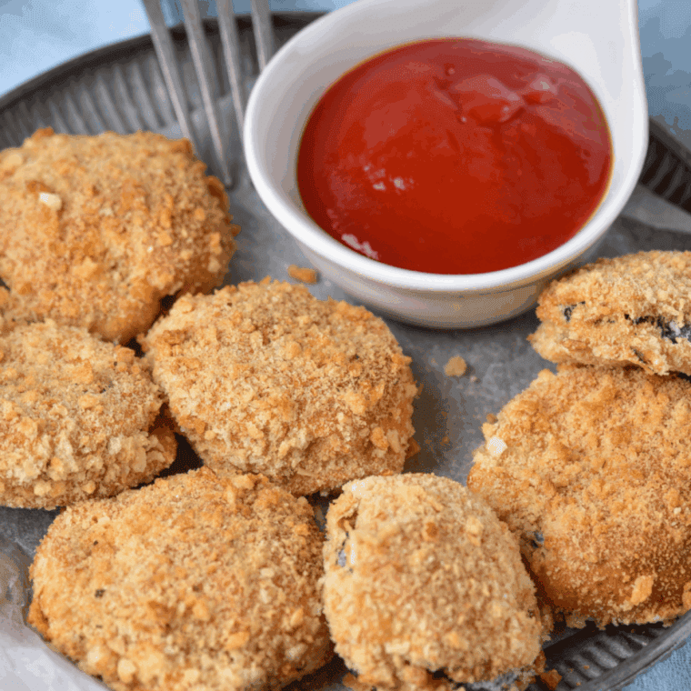Golden crispy air fryer fried zucchini slices, served with dipping sauce, inspired by Cheesecake Factory.
