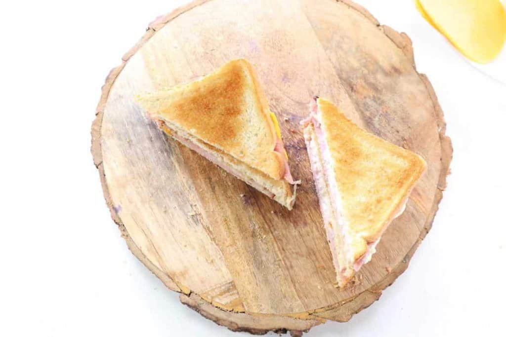 overhead: cooked and sliced ham and cheese sandwich