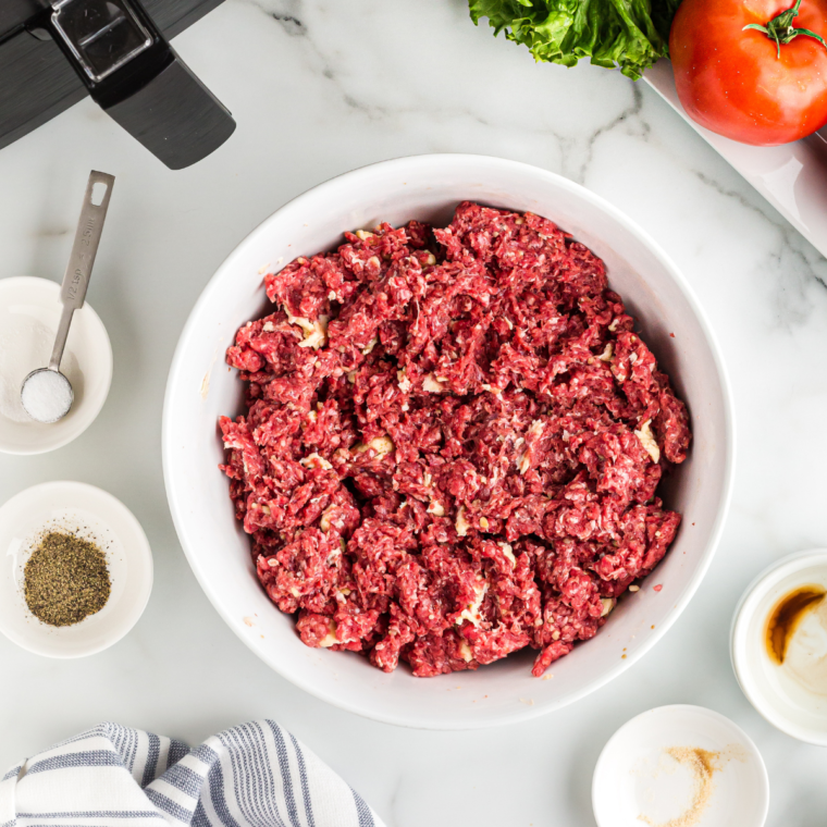 Mixing the ground beef in a large mixing bowl, and season with salt and black pepper. Mix well.