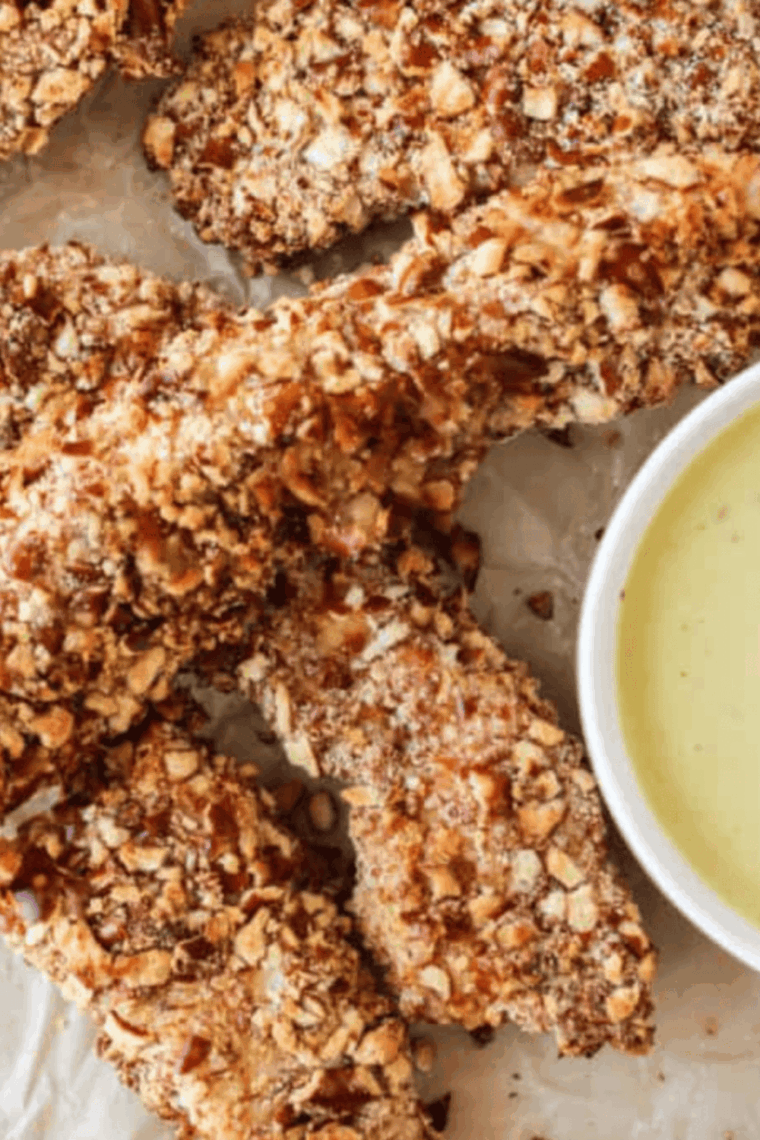 Golden-brown pretzel crusted chicken tenders in an air fryer basket, ready to serve