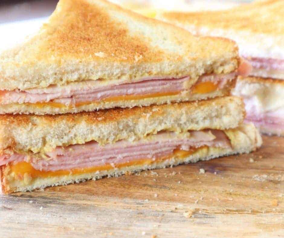a ham and cheese sandwich cut in half with the fillings showing