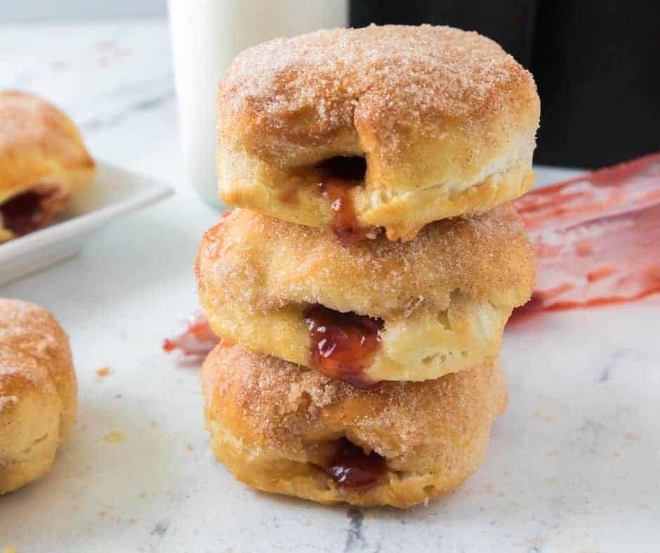a stack of jelly filled donuts with jelly visible