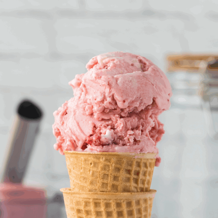 Bowl of creamy strawberry ice cream made with a Ninja Creami, garnished with fresh strawberry slices.