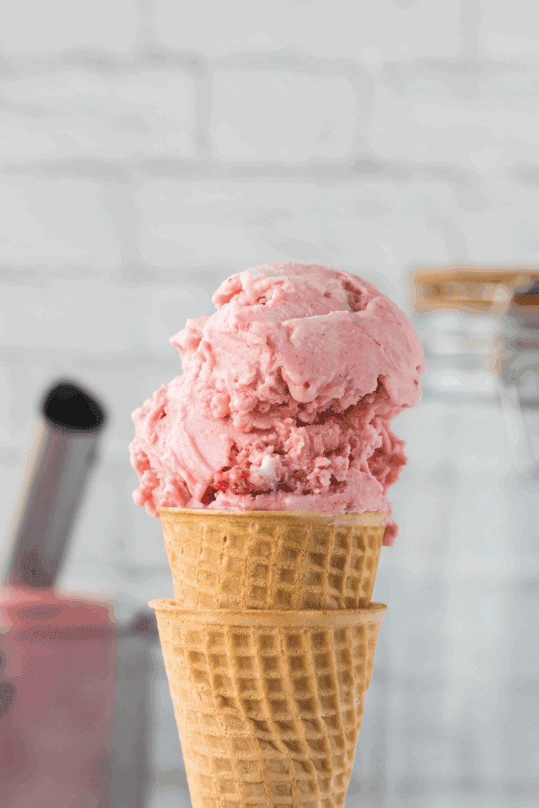 Creamy Ninja Creami strawberry ice cream served in a bowl with fresh strawberries.