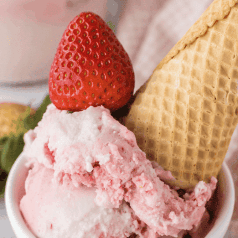 Creamy strawberry ice cream made with Ninja Creami, topped with fresh strawberry slices.