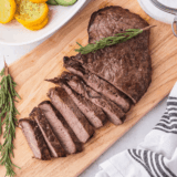 Blackstone sirloin steak with a crispy seared crust sliced on a cutting board