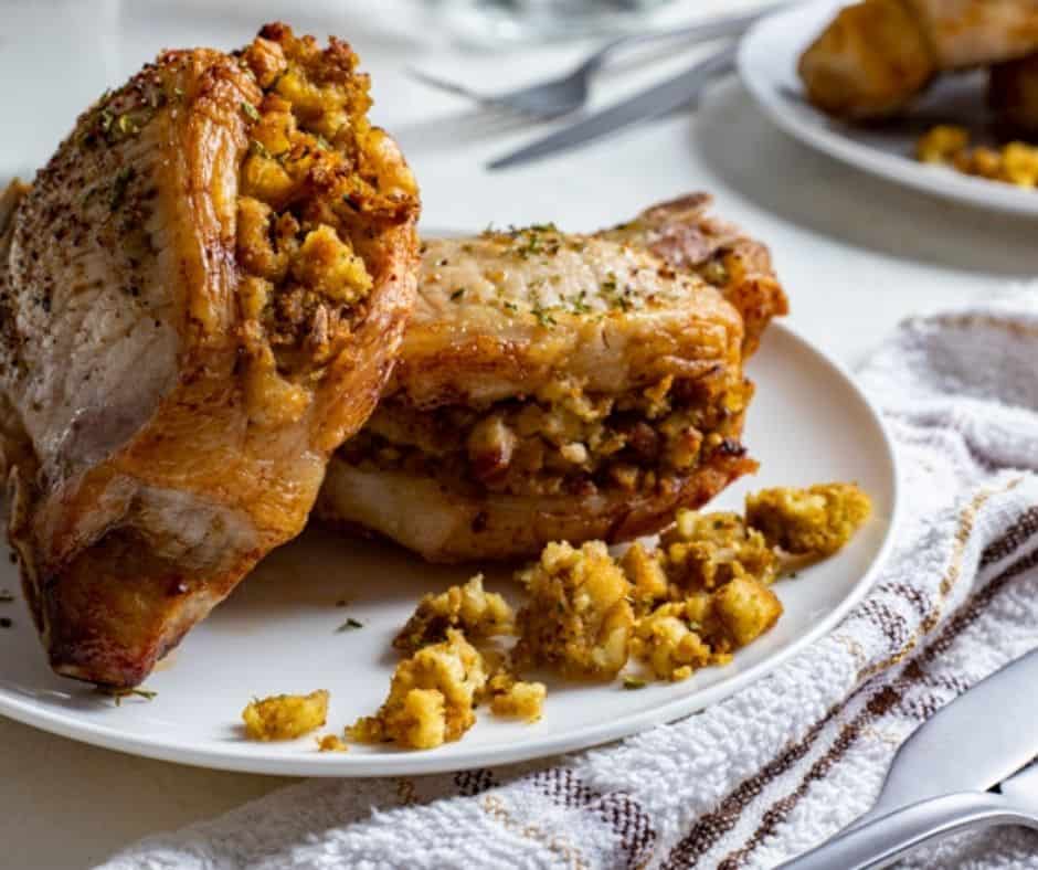 a plate with 2 stuffed pork chops in air fryer with stuffing visible