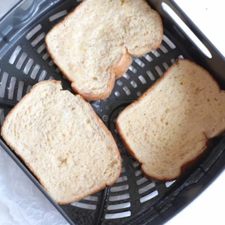 Melted butter drizzled over bread slices before air frying for Air Fryer Apple Pie French Toast.