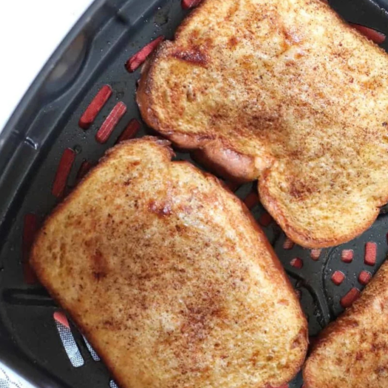 Air Fryer Apple Pie French Toast cooking in the air fryer, golden brown and crispy.