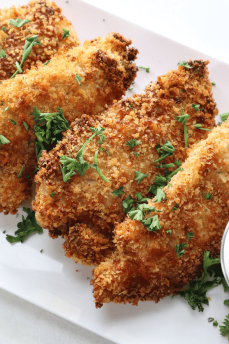 Golden fried chicken tenders plated fresh with ranch, honey mustard, and hot honey for dipping