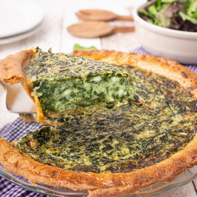 Golden-brown Air Fryer Spinach Quiche with a flaky crust, filled with creamy spinach and cheese, served on a rustic plate.