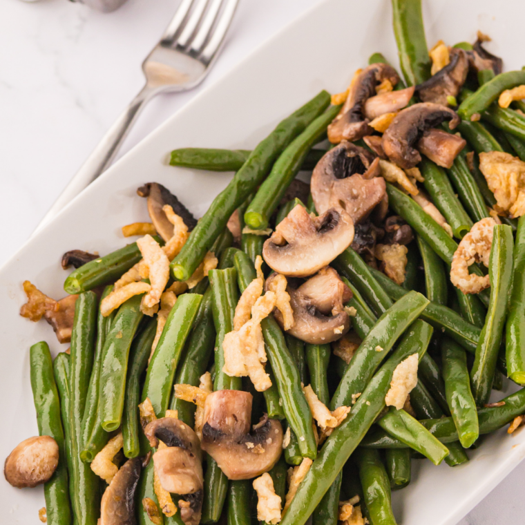 Green beans cooking on outdoor griddle with butter and spices melting over them