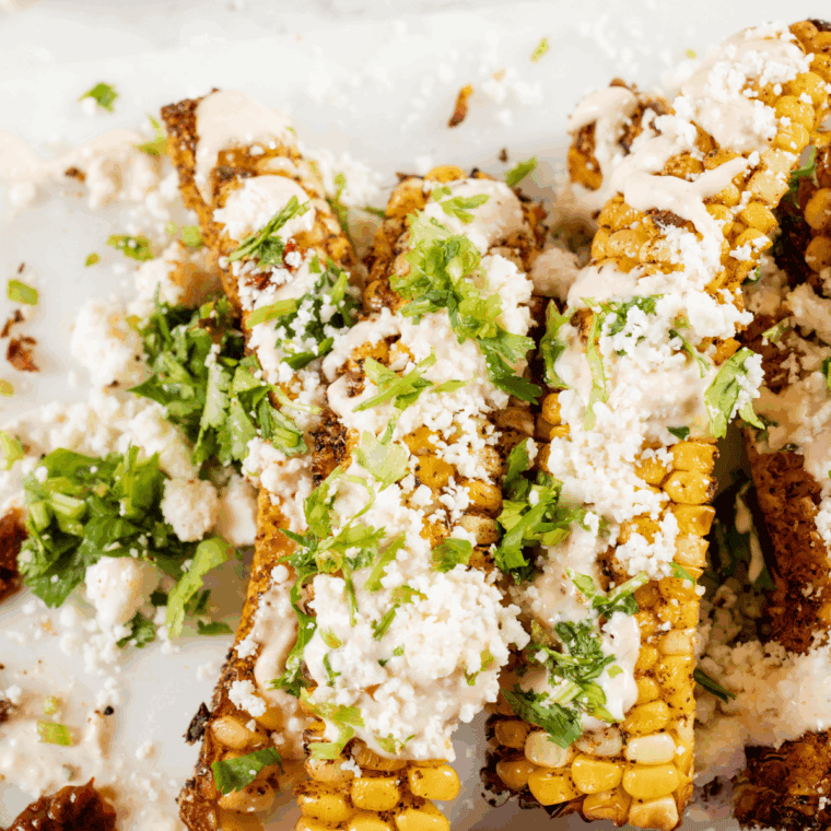Golden-brown corn ribs curled and crisped, served with dipping sauce and herbs.
