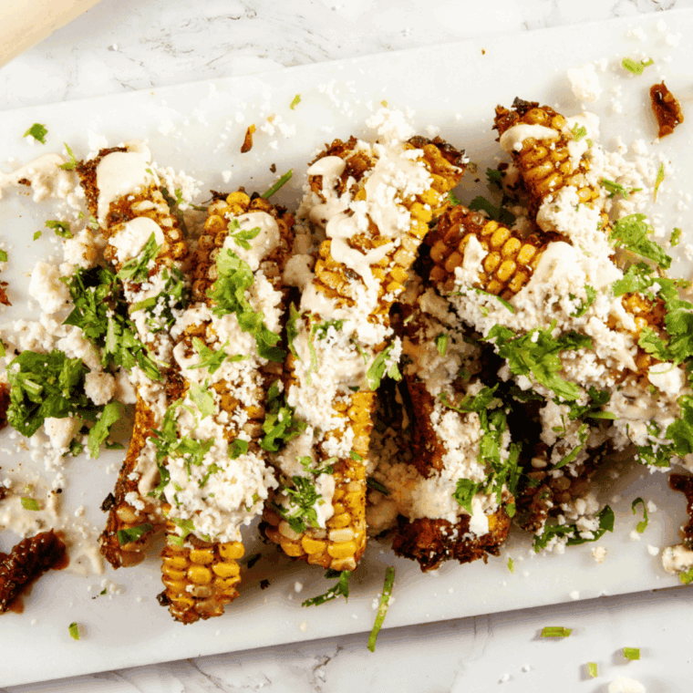 Crispy Cheesecake Factory-style corn ribs served with lime wedges and fresh herbs.