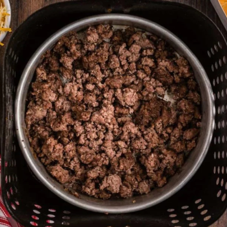 Cooked ground beef in the air fryer basket, in a pan. (oven-safe)