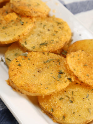 Golden crispy parmesan crusted potatoes in air fryer basket, freshly cooked and ready to serve.