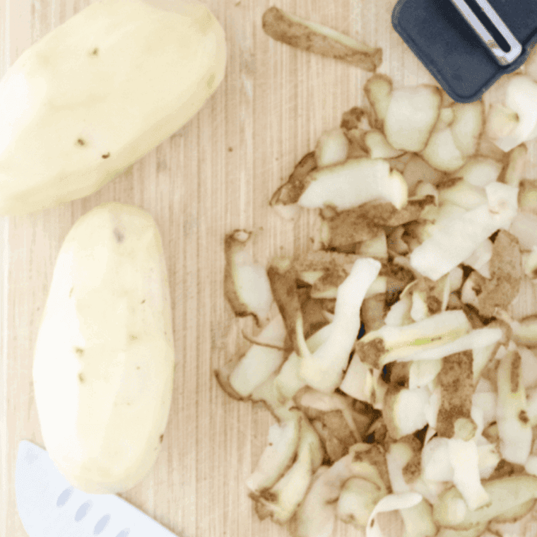 Seasoned shredded potatoes in a bowl being mixed thoroughly to evenly coat with salt, pepper, and spices.