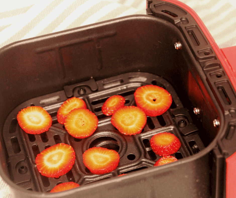 strawberry slices in an air fryer basket