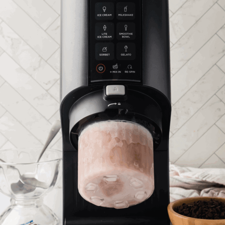 Place the frozen pint container into the Ninja Creami outer bowl, lock it into place, and press the Ice Cream button to process the toffee ice cream until smooth and creamy.