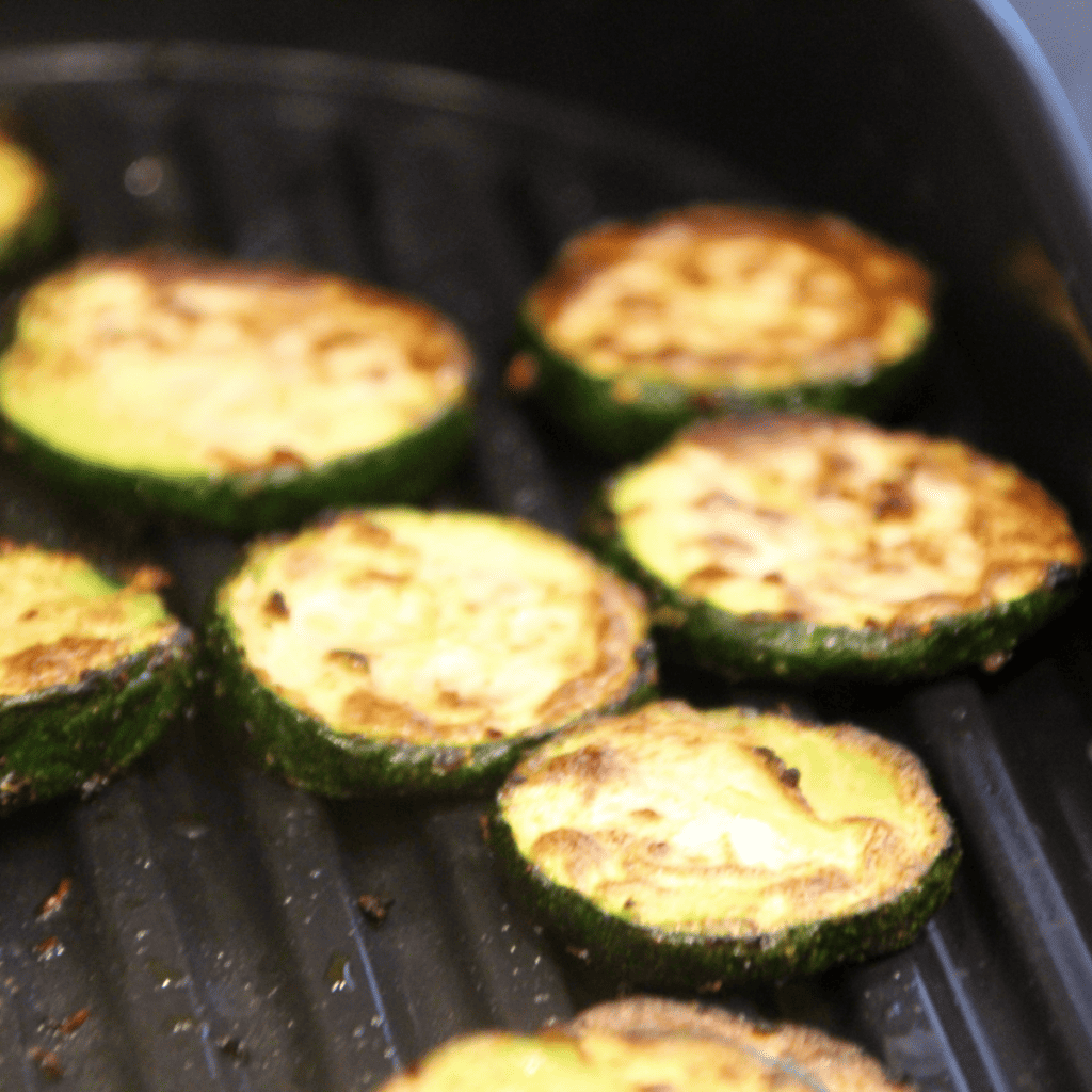 Preheat your Ninja Foodi Grill by selecting the GRILL setting and setting the temperature to medium.

While the grill is preheating, wash the zucchinis and cut off the ends. Slice the zucchinis lengthwise into 1/4 inch thick strips.

Brush the zucchini slices with olive oil on both sides. Then sprinkle with salt, pepper, and any additional herbs or spices if you're using them.

Once the grill is preheated, arrange the zucchini slices on the grill plate. Close the grill and let the zucchini cook for about 3-4 minutes.

Open the grill and flip the zucchini slices over. Close the grill again and let the other side cook for another 3-4 minutes.

Check the zucchini for doneness. The slices should be tender and have nice grill marks. If they're not done to your liking, you can continue grilling for another 1-2 minutes.

Once the zucchini is done, carefully remove it from the grill using a spatula. If desired, sprinkle with grated Parmesan cheese while the zucchini is still hot.

Let the grilled zucchini cool for a few minutes before serving. Enjoy!