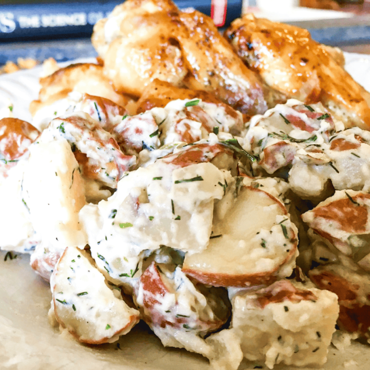 Delicious Air Fryer Potato Salad in a serving bowl with fresh herbs.