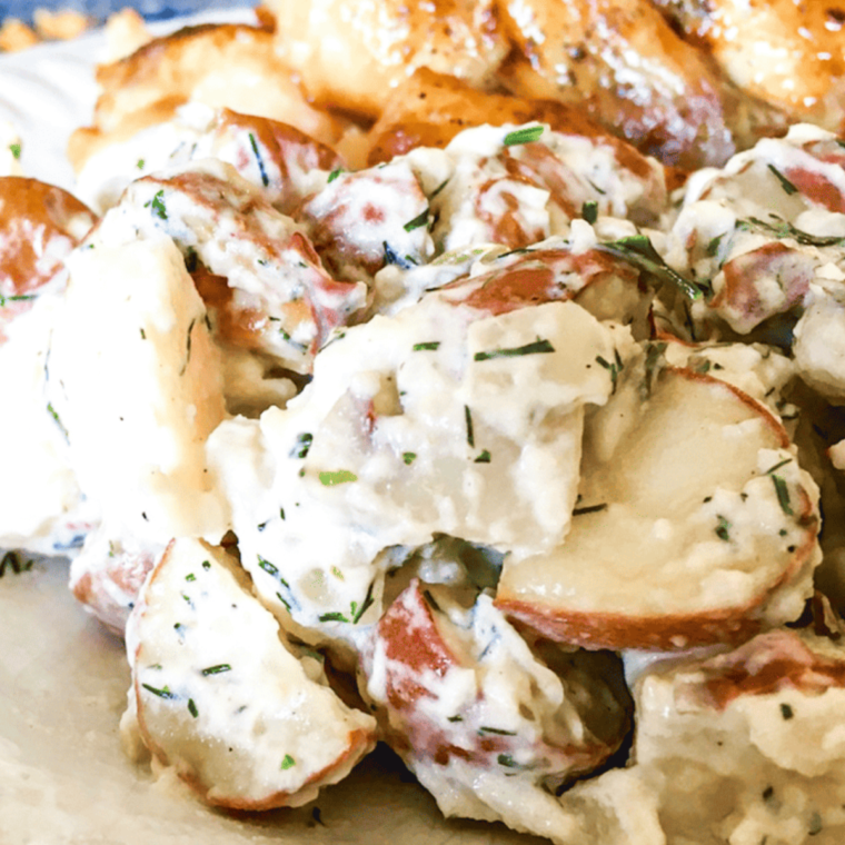 Delicious Air Fryer Potato Salad in a serving bowl with fresh herbs.