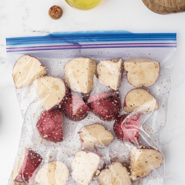 Seasoning diced potatoes with herbs and spices.