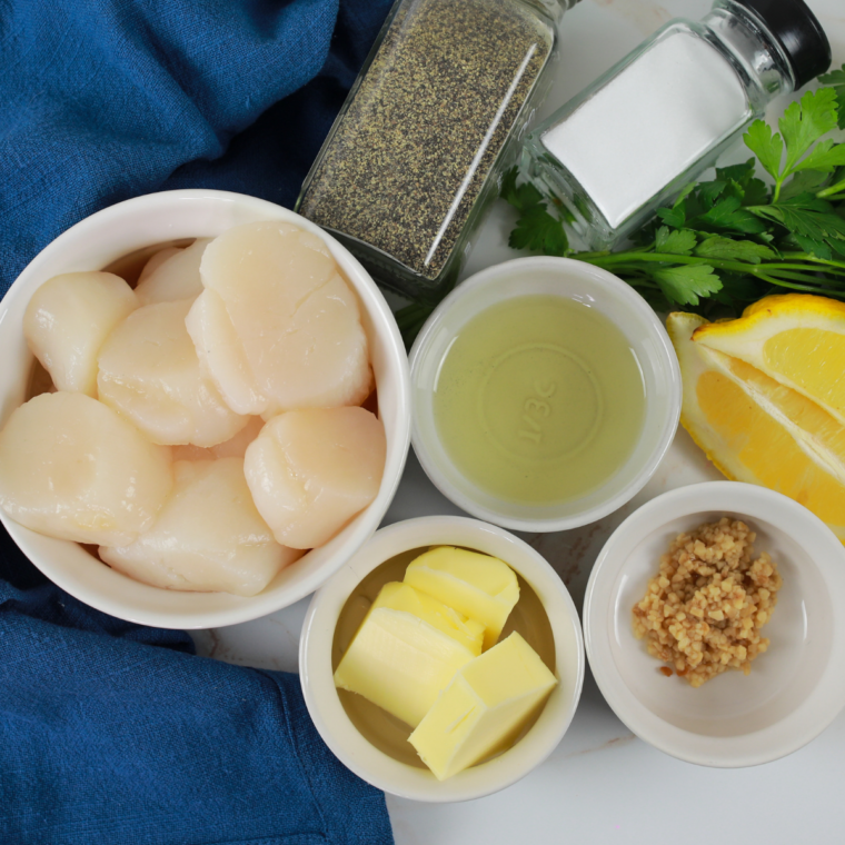 Patting raw scallops dry with paper towels on a cutting board before searing for a crispy crust.