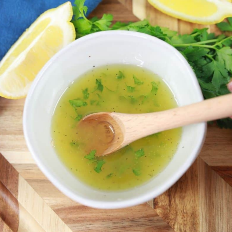 Butter melting on griddle with garlic, lemon juice, and fresh herbs creating a lemon herb sauce.
