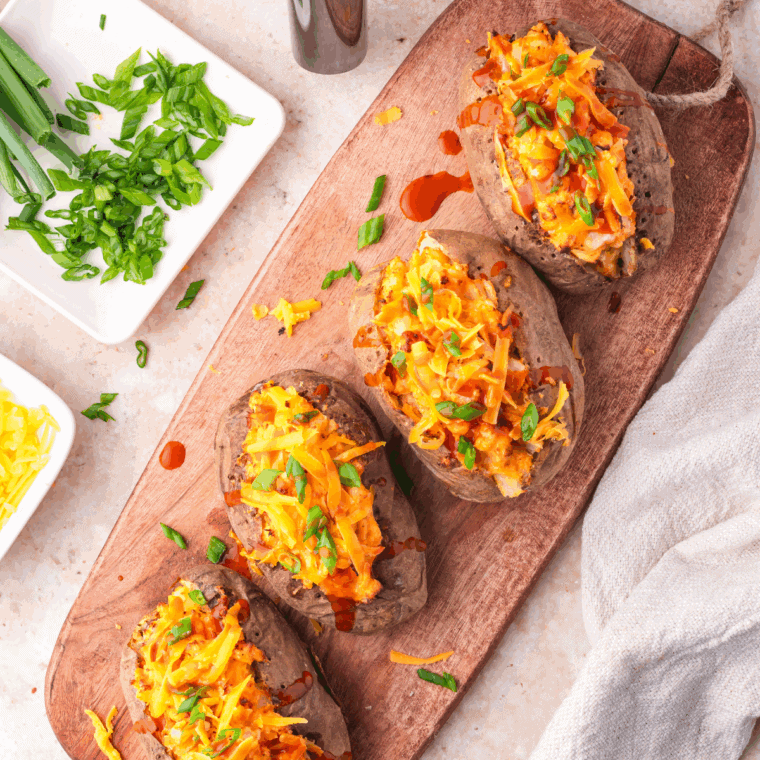 Plate of Cheddar's Scratch Kitchen Baked Potato Recipe on cutting board.