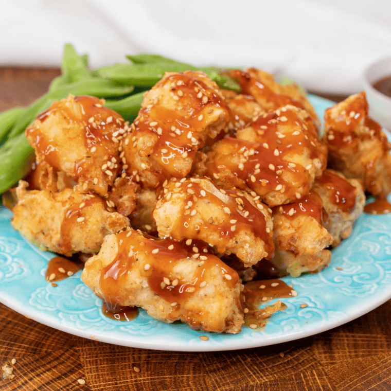 Glossy orange copycat McDonald's sweet and sour sauce in a white ramekin beside golden nuggets.