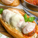 Soft beef meatballs in sweet oregano-forward marinara, tucked into a toasted Italian roll over melted mozzarella. Air fryer or oven.