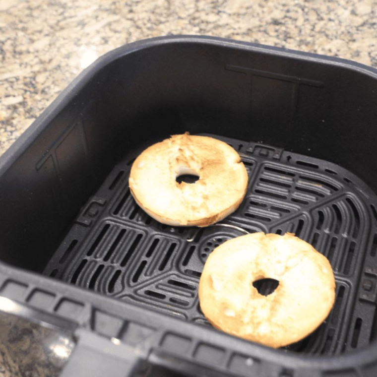 Close-up of bagels in the air fryer, highlighting their crisping exterior during reheating