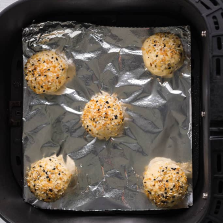 Air fryer with bagels inside, demonstrating the even browning achieved while reheating