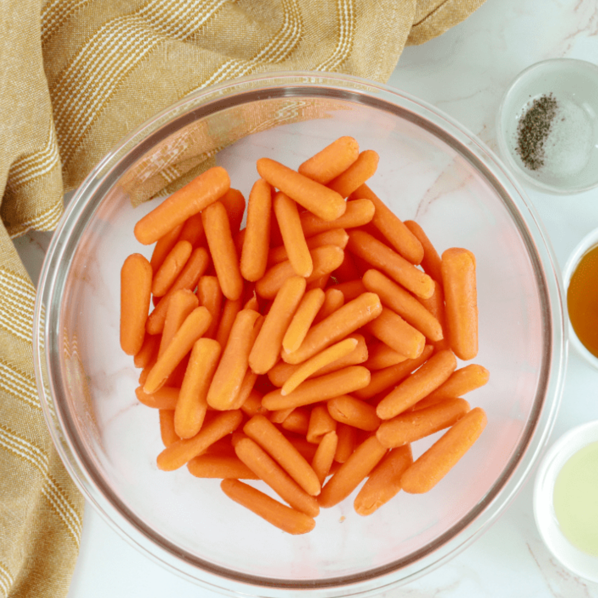 Fresh baby carrots washed and ready for seasoning in a bowl.